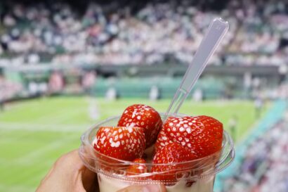 A person holding strawberries and cream at Wimbledon showing trending food at sporting events