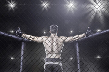 An MMA fighter raising his arms showing who has the most wins in UFC history