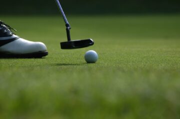 A putter and golf ball showing when is the pga championship